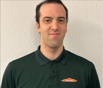 Male employee wearing a green SERVPRO® shirt with white background