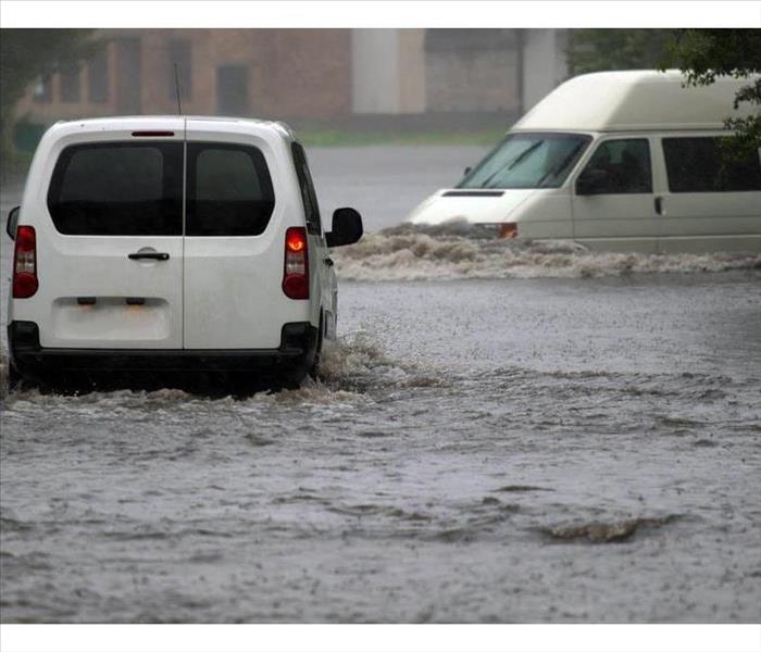 Car rides in heavy rain on a flooded road