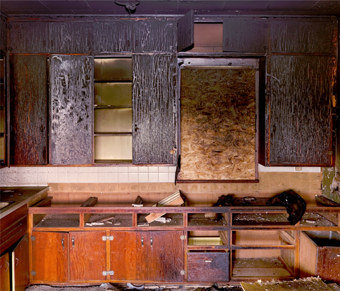 a fire damaged kitchen with burned cabinets