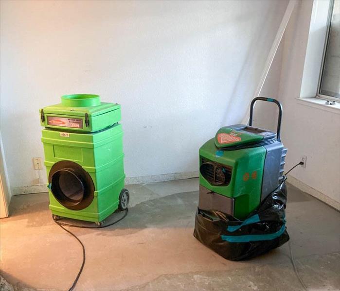 A green dehumidifier and air scrubber in a room.